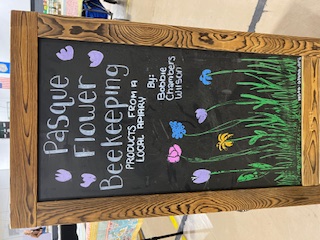 The Pasque Flower Beekeeping chalkboard sign: products from a local apiary, by Bobbie Chambers Wilson, painted with spring flowers